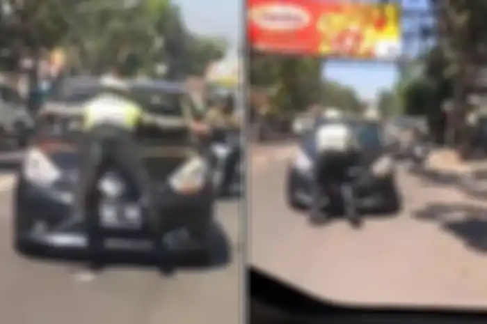Polisi terseret dan berusaha memberhentikan mobil yang melanggar lalu lintas.