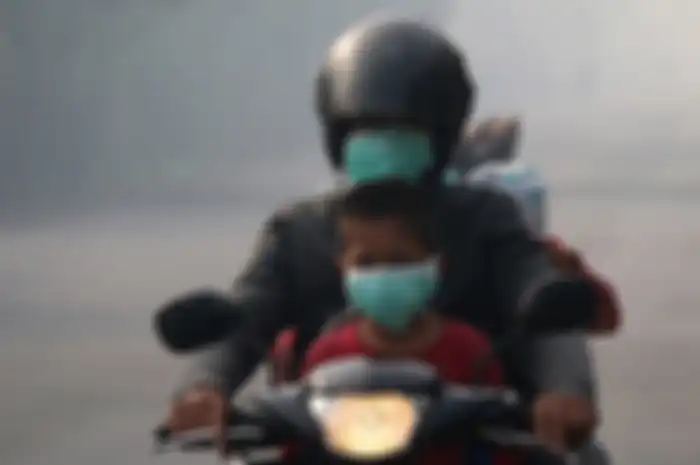 Pengguna jalan menggunakan masker yang dibagikan petugas kesehatan dari Puskesmas Cot Simeureung, Kecamatan Samatiga dan Layung, Kecamatan Bubon, Kabupaten Aceh Barat, menyusul kabut asap kebakaran hutan dan lahan gambut yang sangat pekat, Kamis (1/8/2019). Selain kepada pengguna jalan, masker juga dibagikan kepada siswa empat sekolah yang terdampak kabut asap di Kecamatan Samatiga, yang berada di Desa Suak Timah dan Desa Blang Bale.