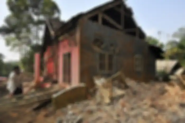 Warga memungut tiang kayu rumahnya yang rusak akibat diguncang gempa di Kampung Karoya, Mandalawangi, Pandeglang, Banten, Sabtu (3/8/2019). Menurut data BPBD Banten satu orang meninggal dan sebanyak 112 rumah rusak berat dan ringan dengan rincian di Lebak sebanyak 12 rumah, di Pandeglang 91 rumah, d