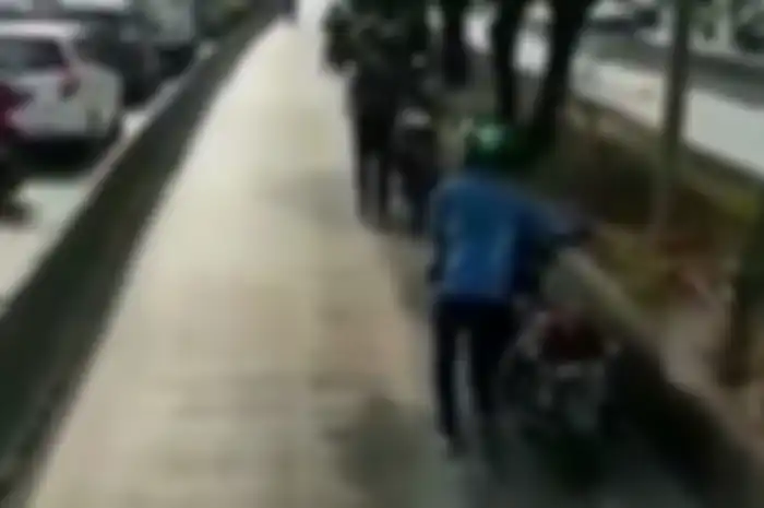 Beberapa pemotor yang masuk jalur Busway dihukum mendorong motornya karena berusaha kabur dari petugas