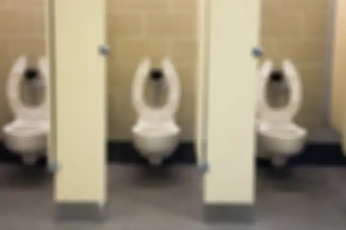Dudukan toilet umum berbentuk huruf 'U'.