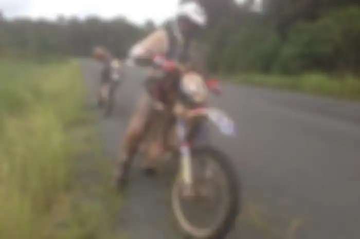 Kadex Ramayadi mengisi jerami di ban motor trail miliknya