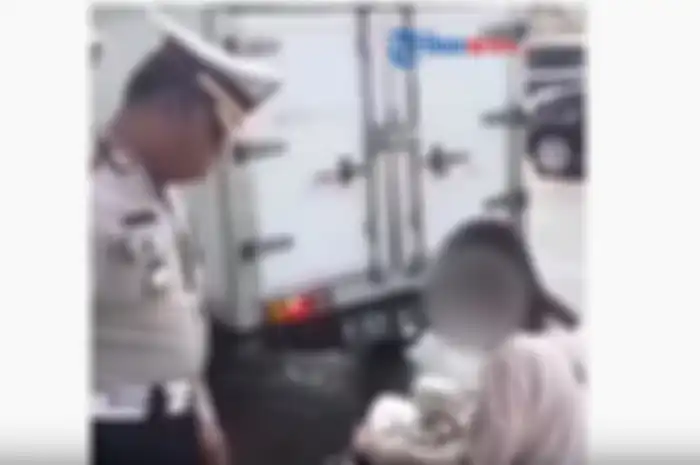 Seorang pemotor wanita hampir nangis saat ditilang oleh petugas kepolisian