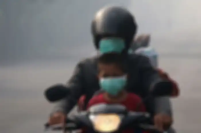 Seorang pemotor Yamaha Mio J di Aceh naik motor pakai masker. Pemerintah Wajibkan Masyarakat Untuk Gunakan Masker Saat Keluar Rumah