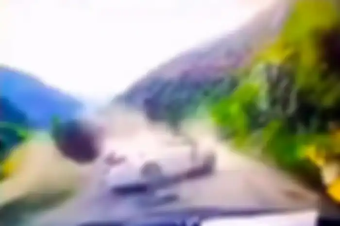 Sebuah mobil yang sedang melaju tertimpa sebuah batu besar yang meluncur dari gunung dan mengenai mobil tersebut