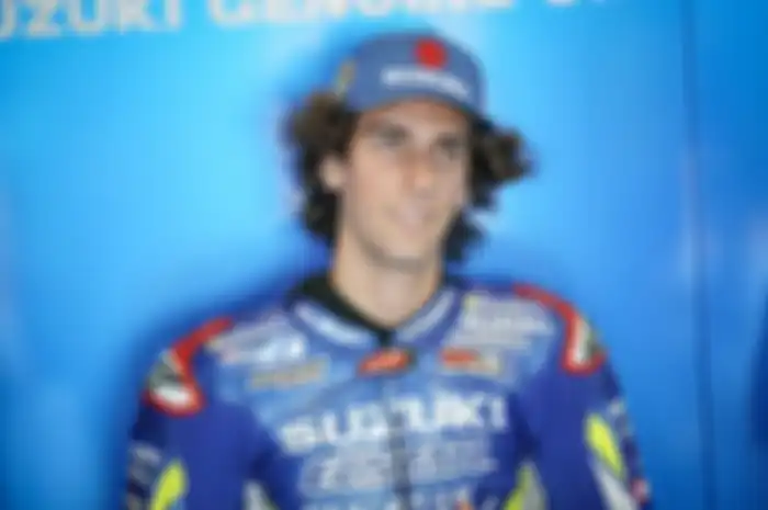 Alex Rins biarkan rambutnya gondrong tak terurus, kalau gak pakai topi lebih mirip grup band reggae ketimbang pembalap MotoGP
