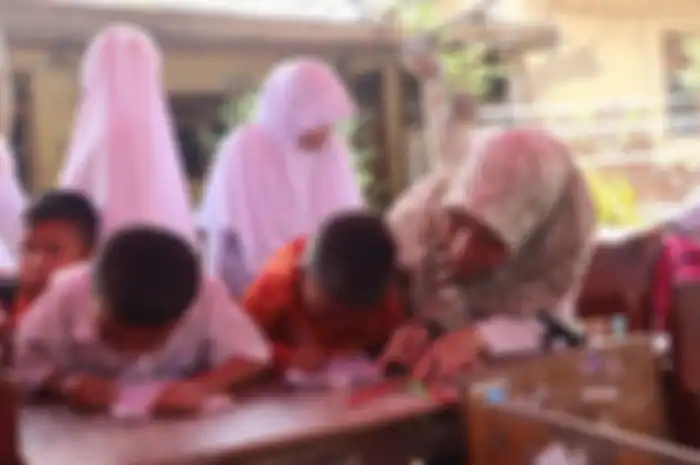 Seorang guru membimbing siswa di SD Negeri Malangsari II, Kecamatan Pedes, Karawang, Jawa Barat, Rabu (16/10/2019). Mereka belajar di kelas darurat.