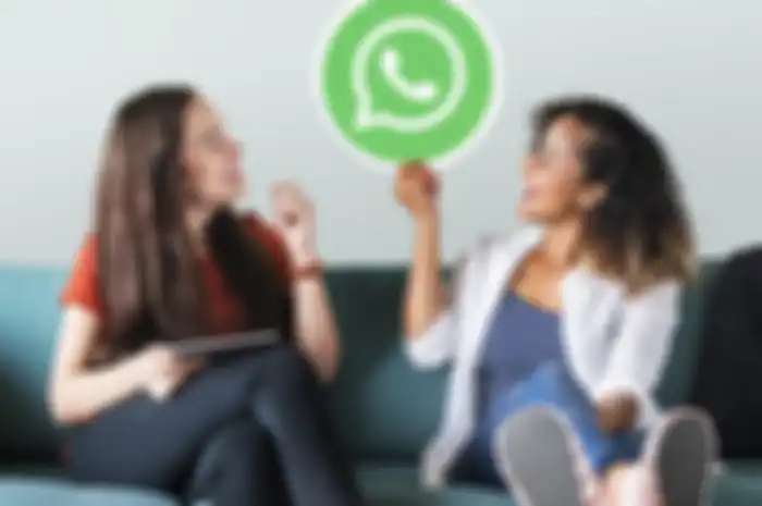 Young women showing a WhatsApp Messenger icon