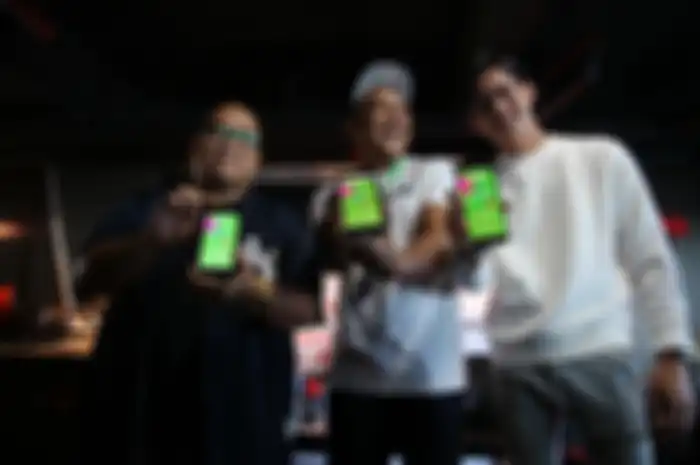 VP Regional Gojek Indonesia Bagian Timur Anandita Danaatmadja (tengah) bersama dua mentor Gojek Smart Fest; Musisi Rap Indonesia Saykoji (kiri) dan Musisi Rey Mbayang (kanan) memperlihatkan fitur edukasi online Gojek Smart Fest saat acara peluncurannya. 