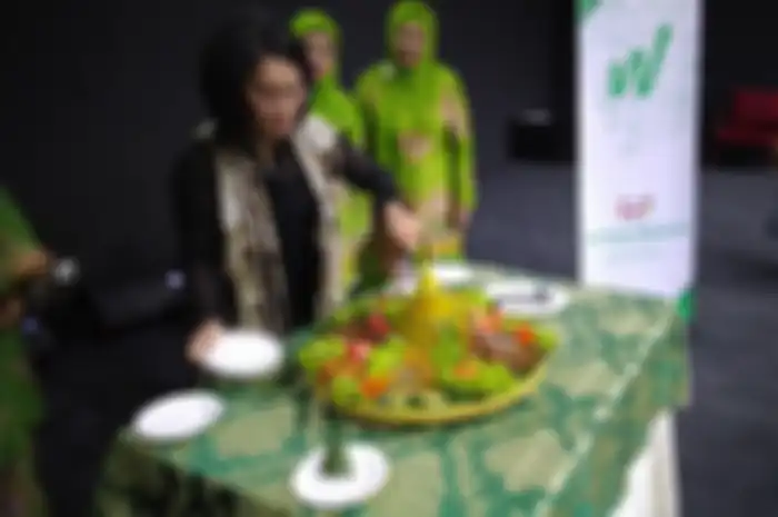 Prosesi potong tumpeng yang dilakukan Nilai Marita, Chief of Corporatef Affairs Gojek