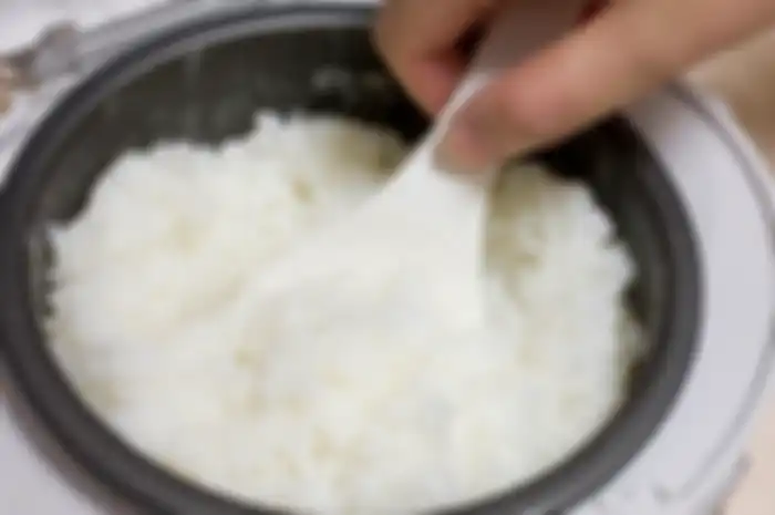Memasak nasi dengan rice cooker atau magic com.