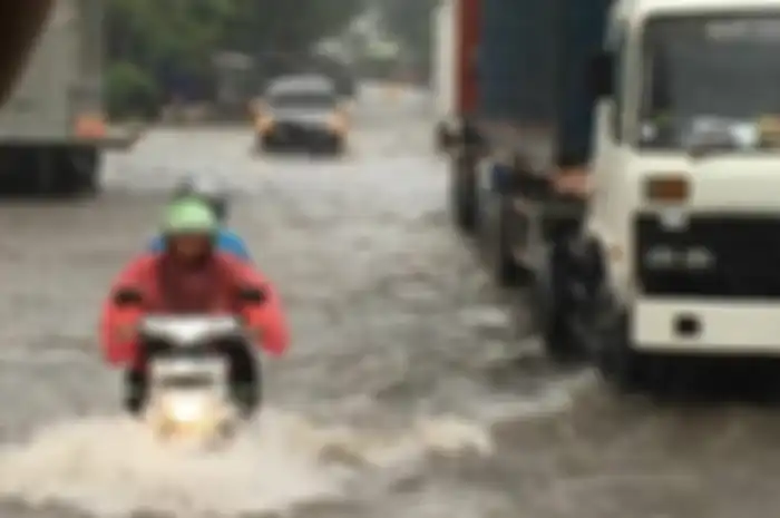 Ilustrasi driver ojek online membawa penumpang di tengah banjir.
