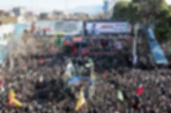 Warga Iran berdatangan di sekeliling mobil yang membawa jenazah Jenderal Qasem Soleimani.