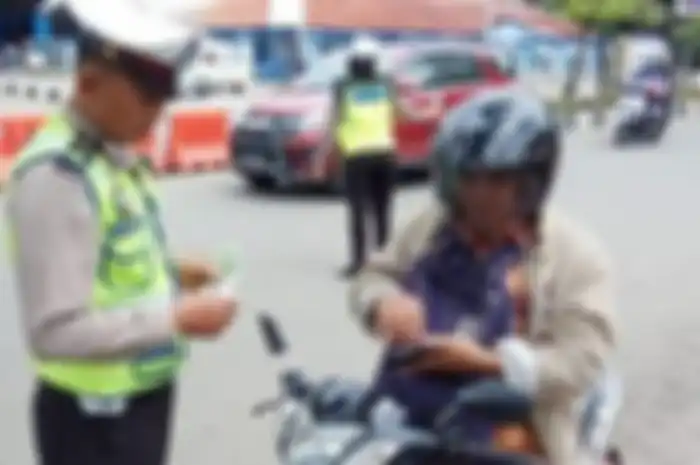 Ilustrasi polisi tilang pengendara motor.