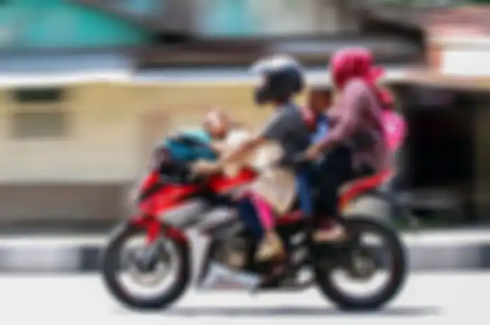 Terlihat sebuah motor sport dinaiki 4 orang penumpang sudah melebihi kapasitas dan hanya seorang yang memakai helm