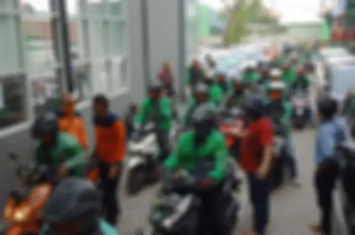 Antrean Ojol untuk mendapatkan semprotan disinfektan di sekitar Terminal Purabaya Surabaya, Sabtu (21/3/2020).