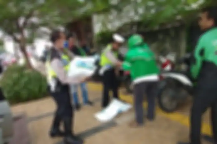 Pembagian bantuan beras kemasan 5 kilogram di halaman Polsek Palmerah, Jakarta Barat.