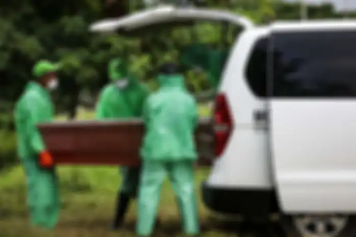 Petugas pemakaman mengeluarkan peti jenazah pasien suspect virus corona atau Covid-19 dari mobil ambulans di TPU Tegal Alur, Jakarta Barat, Kamis (26/3/2020)