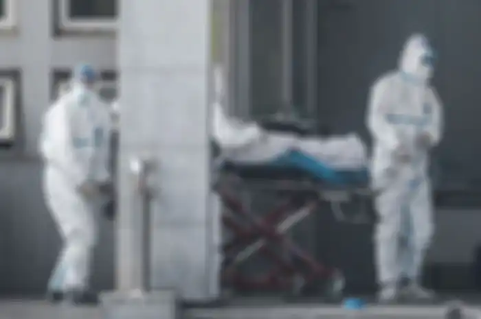 Petugas medis membawa seorang pasien yang diduga terinfeksi virus misterius mirip SARS, ke rumah sakit Jinyintan, di Kota Wuhan, China, Sabtu (18/1/2020).
