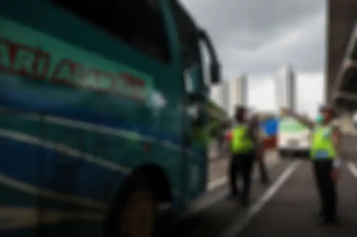 Polisi menghalau mobil bus yang membawa penumpang di jalan tol Jakarta-Cikampek untuk keluar ke Gerbang tol Cikarang Barat, Kabupaten Bekasi, Jawa Barat, Jumat (24/4/2020). Larangan mudik mulai diberlakukan 24 April 2020 pukul 00.00 WIB. Polda Metro Jaya melarang kendaraan pribadi baik motor atau mo