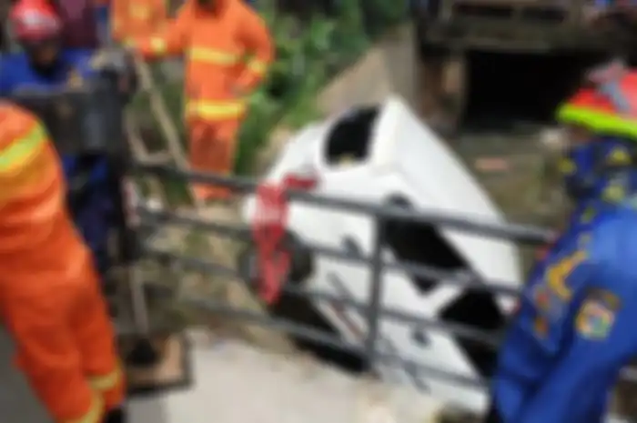 Personel Sudin PKP Jakarta Timur saat proses evakuasi mobil dari kali di Pasar Rebo, Jakarta Timur, Selasa (26/5/2020)&nbsp;akibat hindari kecelakaan menabrak motor yang ngerem mendadak 