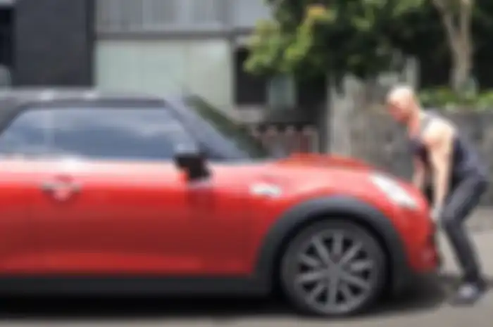 Aksi Deddy Corbuzier saat mencoba mengangkat Mini Cooper dengan tangan kosong