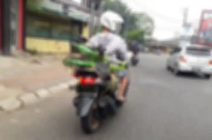  Ilustrasi membawa sepeda di motor. Apakah Membawa Sepeda di Jok Belakang Motor Termasuk Pelanggaran Lalu Lintas?