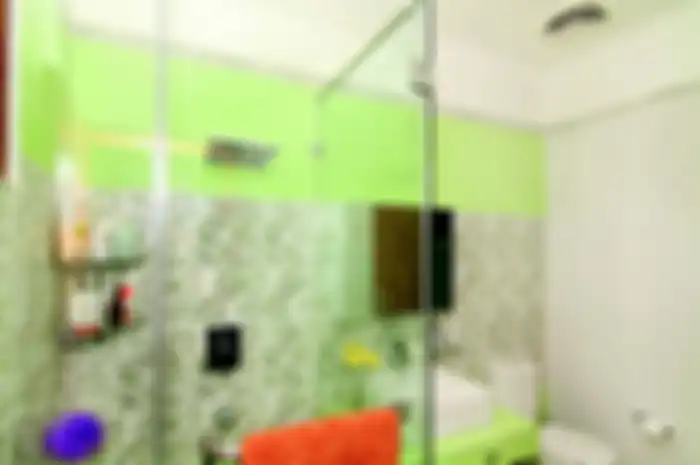 Keramik motif bunga dipadu dinding hijau memberi kesegaran di kamar mandi.