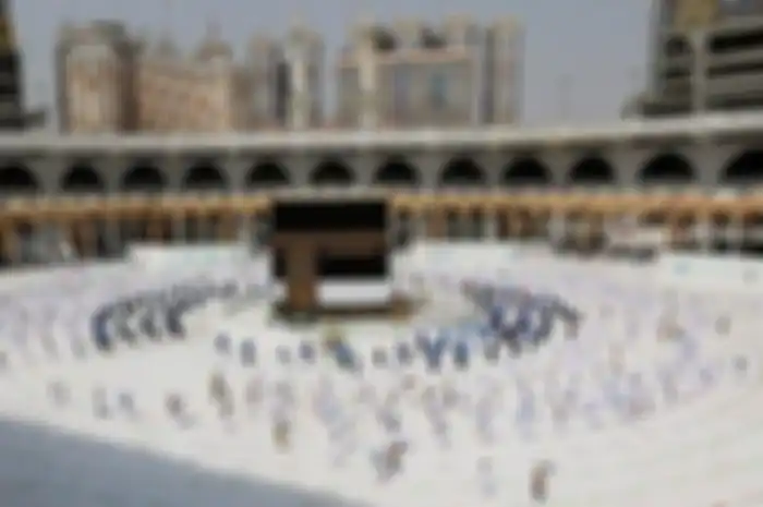 Jamaah berpakaian ihram sedang tawaf mengelilingi Kabah dengan mengikuti garis melingkar di pelataran Kabah. Tahun ini, hanya 13 orang WNI yang ikut pelaksanaan haji 2020, mereka saat ini tinggal di Arab Saudi 
