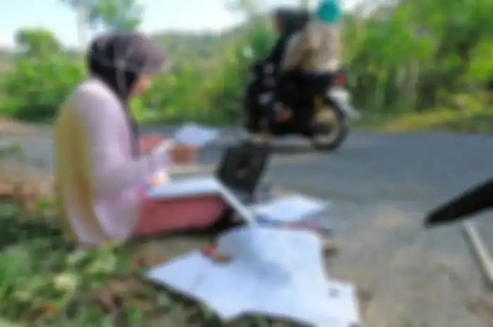 Seorang mahasiswa jurusan manajemen Universitas Muhammadiyah Magelang Teara Noviani (kiri) mengerjakan Ujian Tengah Semester secara daring di pinggir jalan kawasan pegunungan Menoreh di Desa Kenalan, Borobudur, Magelang, Jawa Tengah, Senin (20/7/2020). Teara mengaku kesulitan mendapatkan sinyal internet di wilayahnya, sehingga setiap hari terpaksa mengerjakan tugas kuliah dan ujian di pinggir jalan yang sinyal internetnya kuat.