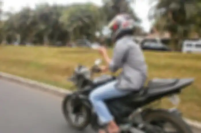 Ilustrasi naik motor sambil main HP.