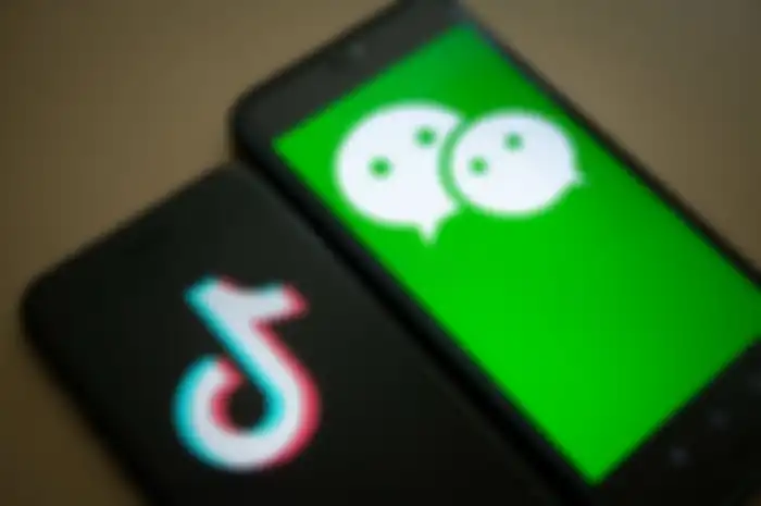 The logo for Tencent Holdings Ltd.'s WeChat app, right, and the logo for ByteDance Ltd.'s TikTok app are arranged for a photograph on smartphones in Hong Kong, China, on Friday, Aug. 7, 2020. President Donald Trump signed a pair of executive orders prohibiting U.S. residents from doing business with