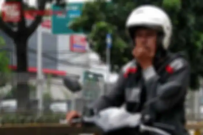 Ilustrasi naik motor sambil merokok.