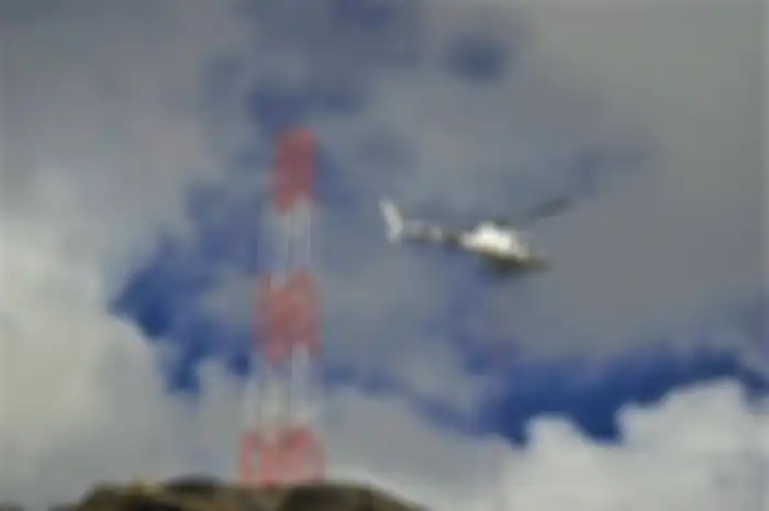 Proses pembangunan proyek Palapa Ring Timur. Karena sulitnya medan, komponen menara BTS diangkut helikopter