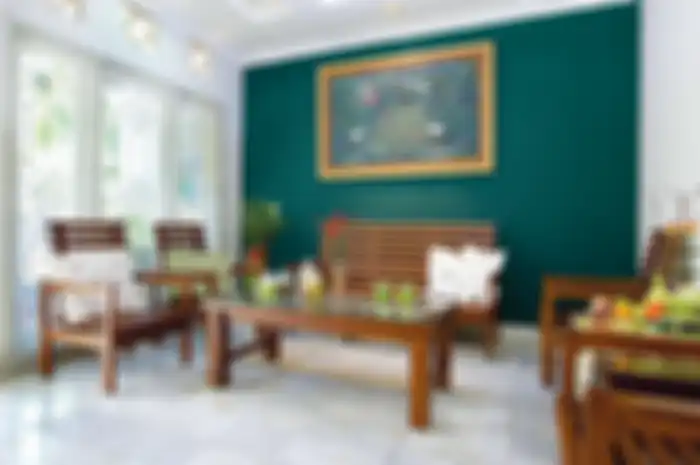 Ruang tamu yang serba putih bersih ini diberi aksen yang kuat, yakni satu sisi dindingnya dicat warna hijau terang.
