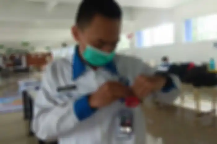 M. Rafhi Rihadatusyawal dari SMK Mitra Industri MM2100, Jawa Barat menguji alat penjaga jarak fisik temuannya.