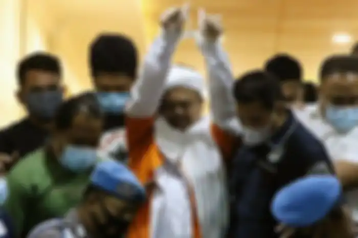 Pemimpin Front Pembela Islam (FPI) Muhammad Rizieq Shihab mengenakan baju tahanan seusai menjalani pemeriksaan di Polda Metro Jaya, Jakarta Pusat, Minggu (13/12/2020) dini hari. 