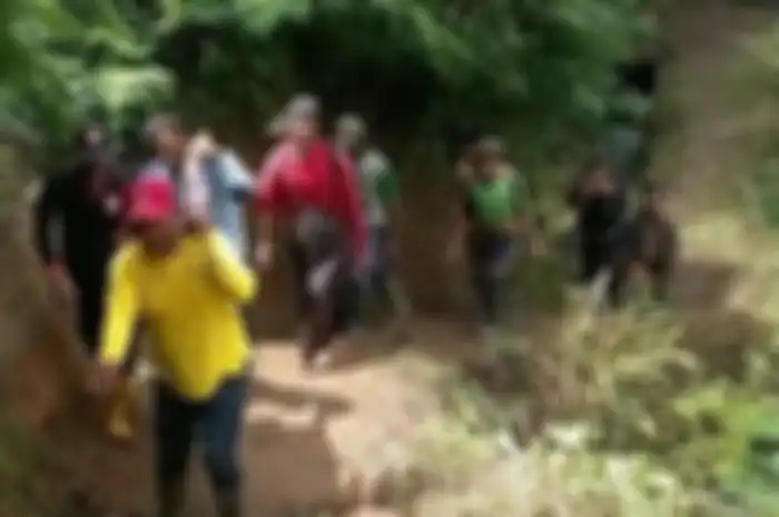 Warga bersama petugas mengevakuasi jasad Saeful dengan cara ditandu dengan kain sarung menuju mobil petugas.