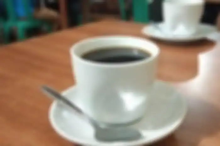 Ilustrasi menikmati secangkir kopi di pagi hari.