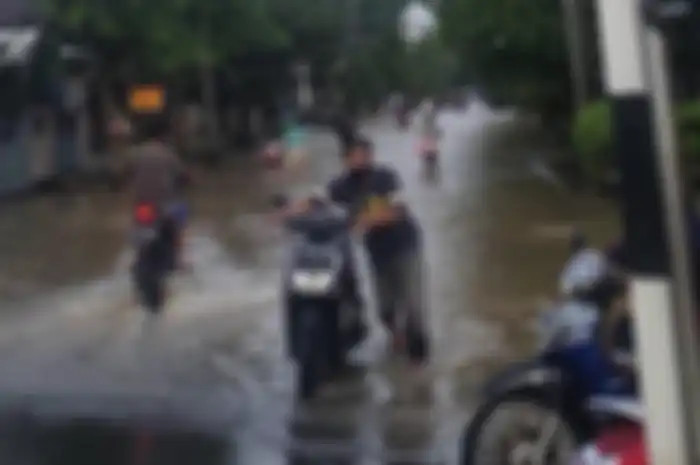 ILUSTRASI. Saat motor terobos banjir, lebih baik didorong saja daripada dinyalakan. Ini alasannya!