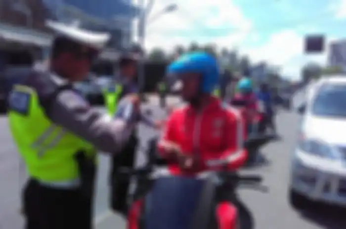 Polisi sedang memeriksa kelengkapan surat-surat berkendara termasuk SIM