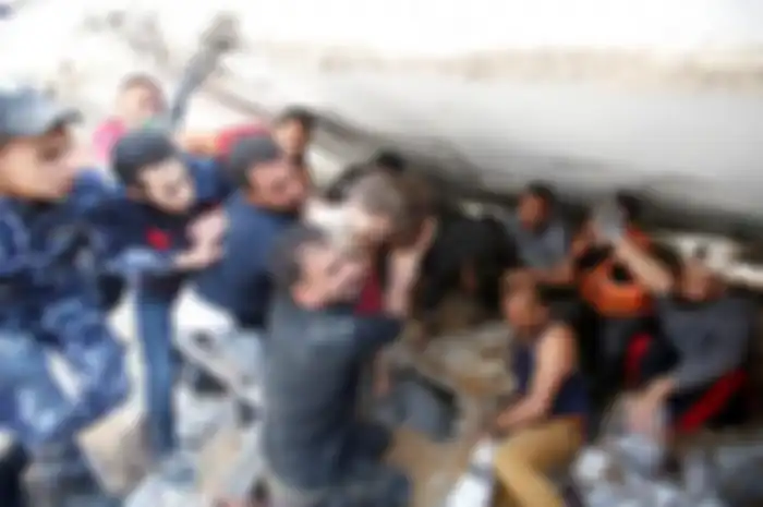 Warga Palestina menyelamatkan Suzy Eshkuntana yang berusia 6 tahun dari puing-puing rumahnya setelah serangan udara oleh tentara Israel di lingkungan al-Rimal Kota Gaza, Gaza, pada 16 Mei 2021.