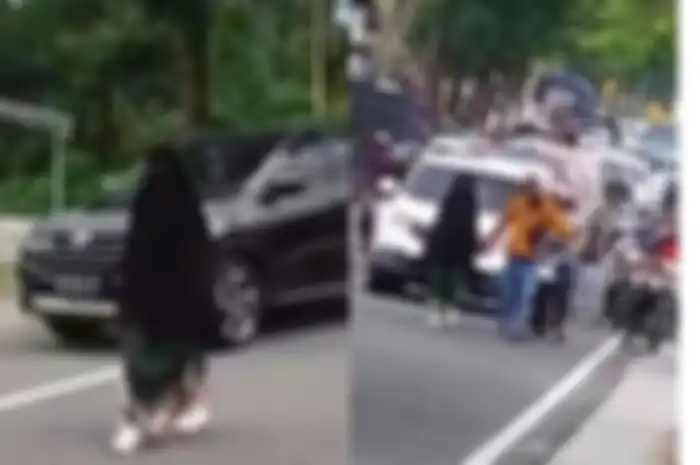 Wanita bercadar terekam kamera video berjalan santai di tengah jalan hingga menimbulkan kemacetan. Polisi ungkap fakta sebenarnya.