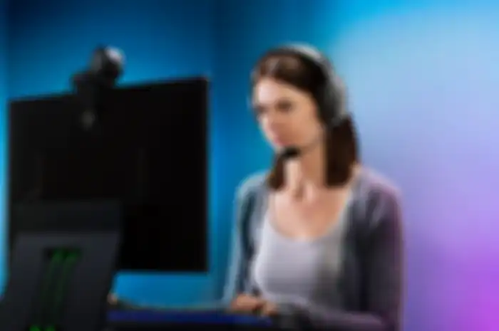 Ilustrasi seorang wanita menggunakan headset gaming Razer Barracuda X untuk bermain game PC