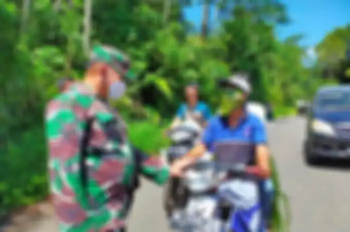 Panik melihat banyak petugas, petani ini membuat masker dadakan dari daun. 