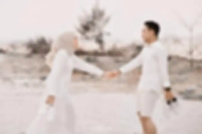 Ilustrasi foto prewedding. Demi mendapatkan foto aesthetic, pria ini bersembunyi di balik gaun panjang calon mempelai wanita.