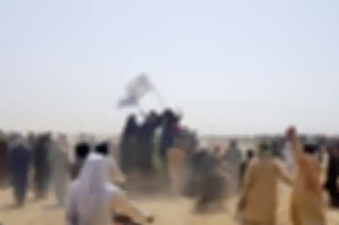 People standing on a vehicle hold Taliban flags as people gather near the Friendship Gate crossing point in the Pakistan-Afghanistan border town of Chaman, Pakistan July 14, 2021. Picture taken July 14, 2021. REUTERS/Abdul Khaliq Achakzai