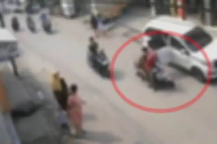 Pemotor dan boncenger langsung nyungsep ke jalanan akibat pintu mobil dibuka sembarangan.