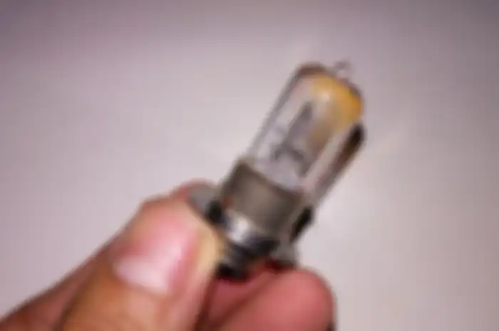 Ilustrasi jangan sembarangan memegang bohlam lampu halogen motor.