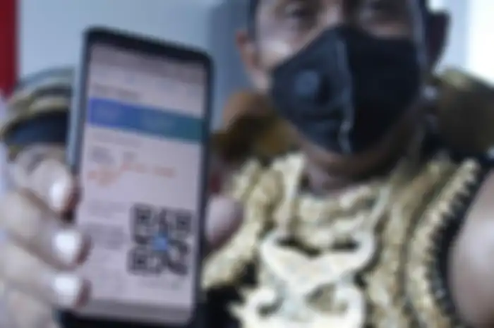 Penerima vaksin berkostum wayang Partika Subayo Lelono menunjukkan tiket elektronik penerima vaksin COVID-19 produksi Sinovac di Rumah Sakit Umum Daerah (RSUD) Bung Karno, Solo, Jawa Tengah, Jumat (22/1/2021). Aksi tersebut untuk memberikan dukungan terhadap program vaksinasi COVID-19 dari pemerintah dengan menggunakan vaksin yang aman.